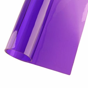 May include: A roll of translucent purple plastic film. The film is rolled up and the end is curled over.