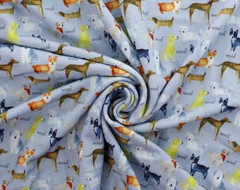 May include: A blue fabric with a repeating pattern of colorful dogs and the word "woof" printed on it. The fabric is textured and has a waffle-like appearance.