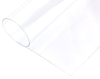 May include: A clear plastic sheet rolled up, showing the smooth, transparent surface. The sheet is flexible and can be used for various craft projects.