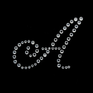May include: A white rhinestone design on a black background. The design is a swirl and a curved line.