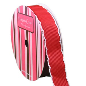 Op de afbeelding: Een rol rood lint met een witte gegolfde rand. Het lint zit op een rol met een roze en bruin gestreept etiket waarop "Hair Bow Center - The supply store" staat.