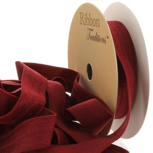 May include: A spool of burgundy red ribbon with the text "Ribbon Traditions™" on the label.