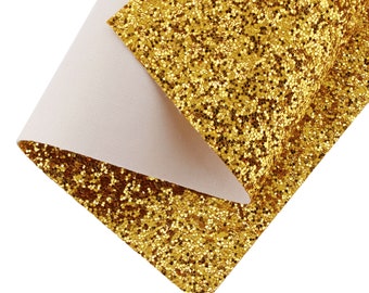 May include: Gold glitter fabric with a white backing. The fabric is folded in half, showing both sides.