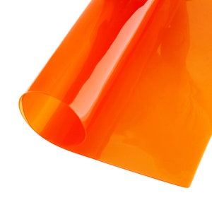 May include: A bright orange sheet of translucent plastic, folded in half, with a slight curve in the fold.