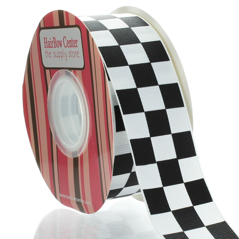 May include: A roll of black and white checkered ribbon. The ribbon is 1.5 inches wide and is ideal for crafting, decorating, and gift wrapping. The ribbon is on a spool with a label that says "HairBow Center the supply store".