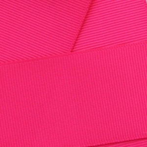 May include: A close-up of a bright pink ribbon with a ribbed texture.