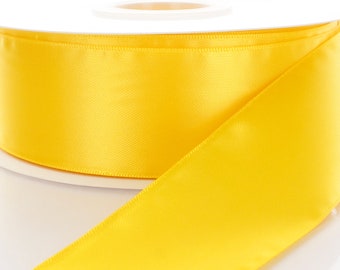 Puede incluir: Un carrete de cinta de satén amarillo brillante. La cinta es lisa y brillante, y es perfecta para agregar un toque de elegancia a cualquier proyecto.