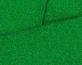 May include: A close-up of a green fabric with a sparkly, textured surface.