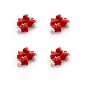 May include: Four red and white candy cane ornaments with a bow on top. The ornaments are made of plastic and are perfect for decorating a Christmas tree.