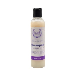 May include: A clear plastic bottle of Lavish Wellness Shop Intense Hydrating shampoo with a black flip-top cap. The label features a purple floral wreath logo, the text Intense Hydrating shampoo, and states it contains 236 ml of product.