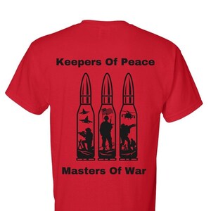 May include: Red t-shirt with black text that reads "Keepers Of Peace" and "Masters Of War". The text is centred on the shirt and is surrounded by three black silhouettes of bullets. Each bullet contains a silhouette of a soldier, a jet, and a helicopter.