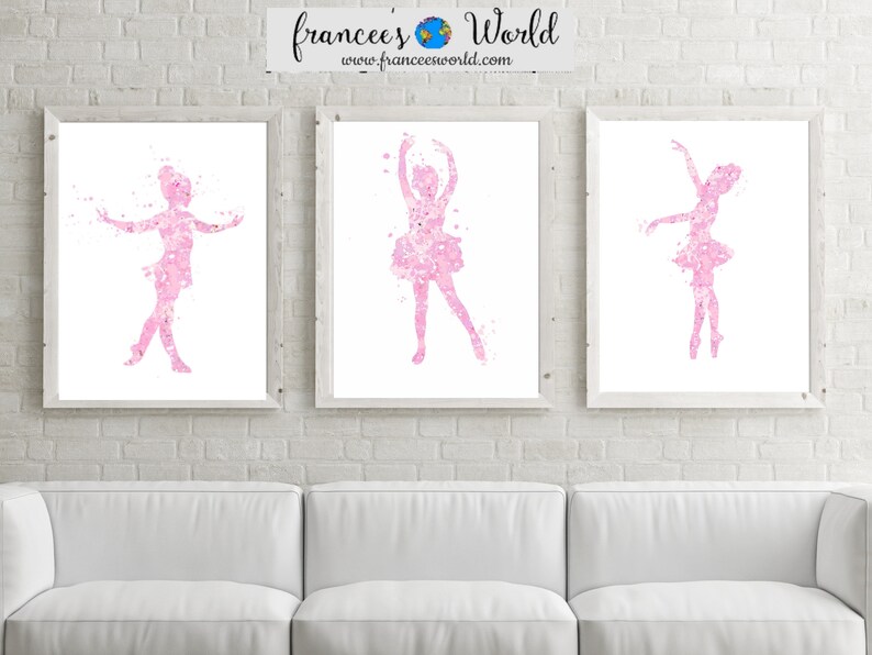May include: Three framed watercolor prints of pink ballerina silhouettes on a white brick wall. The ballerinas are in different poses, with their arms outstretched and their legs in various positions. The prints are all the same size and are arranged in a row.