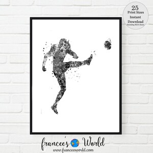May include: Black and white watercolor painting of a soccer player kicking a ball. The player is in mid-air with their leg extended and their foot about to make contact with the ball. The painting is done in a splatter style, with the paint creating a sense of movement and energy.