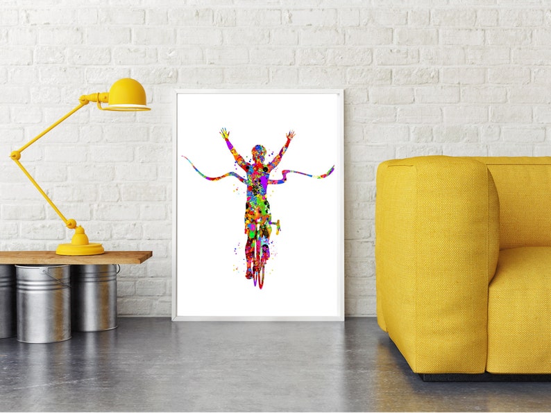 May include: A colorful watercolor painting of a cyclist crossing a finish line with arms raised in victory. The cyclist is depicted in a vibrant array of colors, with a splash of yellow, red, blue, green, and purple.