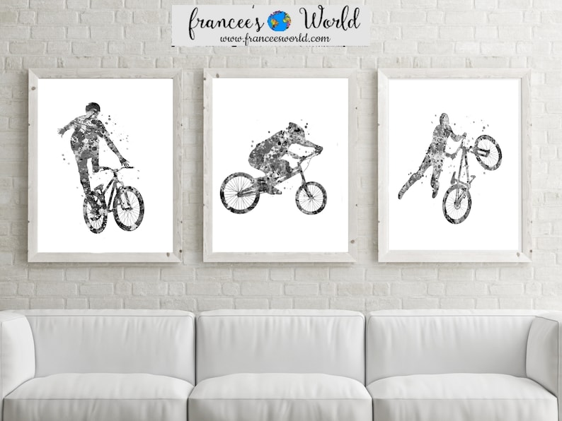 May include: Three black and white watercolor paintings of people riding bicycles. The paintings are framed and hung on a white brick wall above a white couch.