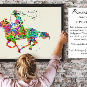 May include: A framed watercolour print depicting a cowboy on horseback, created in a vibrant splatter-paint style. The artwork shows a cowboy with a lasso, riding a horse, using a colourful palette of red, green, blue, and yellow. The print is labelled "Printable Art".