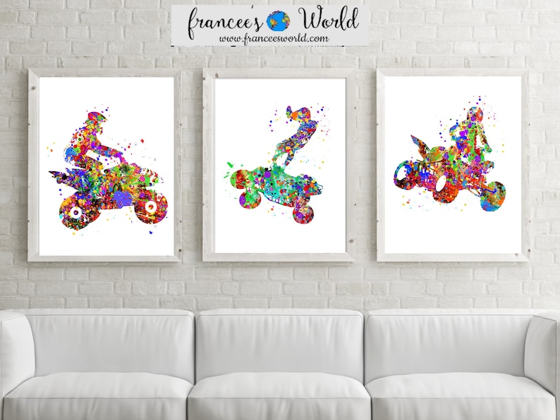May include: Three watercolor paintings of people riding ATVs. The paintings are in a variety of colors, including red, blue, green, and yellow. The paintings are framed in white frames and are hanging on a white brick wall.