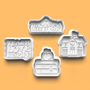 May include: Set of four white plastic cookie cutters with teacher-themed designs. The cutters feature the phrases "Teach Love Inspire" and "Teaching is a Work of Heart", a schoolhouse, and a stack of books with an apple on top.