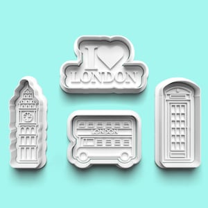 May include: Set of four white plastic cookie cutters shaped like London landmarks: Big Ben, a double-decker bus, a telephone box, and a heart with "I Love London" text.