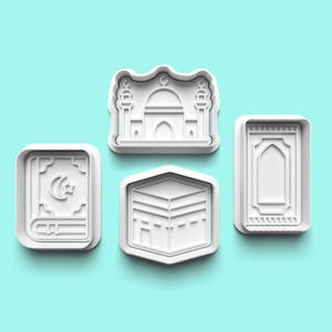 Peut inclure: Ensemble de quatre emporte-pièces en plastique blanc en forme de symboles religieux islamiques : une mosquée, un livre, un tapis de prière et la Kaaba.