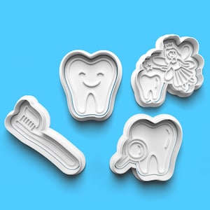 May include: Set of four white plastic cookie cutters shaped like a toothbrush, a tooth with a mirror, a tooth with a smiling face, and a tooth fairy with wings and a wand.