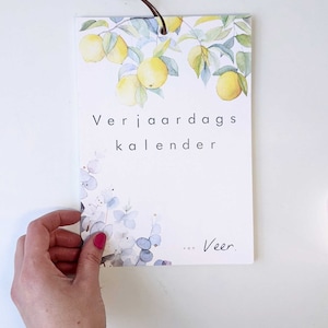 May include: A white card with a watercolour illustration of lemons on a branch. The text "Verjaardags kalender van Veer." is printed on the card.