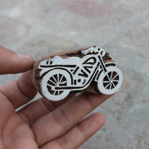 Peut inclure: Une sculpture en bois d'une moto peinte en blanc. La sculpture est détaillée et comprend les roues, le guidon et le moteur de la moto.