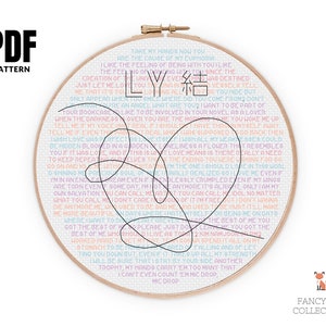 May include: A PDF pattern for cross-stitch embroidery featuring a heart shape with lyrics from the song 'LY' by the K-pop group, 'TXT'. The lyrics are in a variety of colors, including pink, blue, and yellow. The pattern is surrounded by a white background.