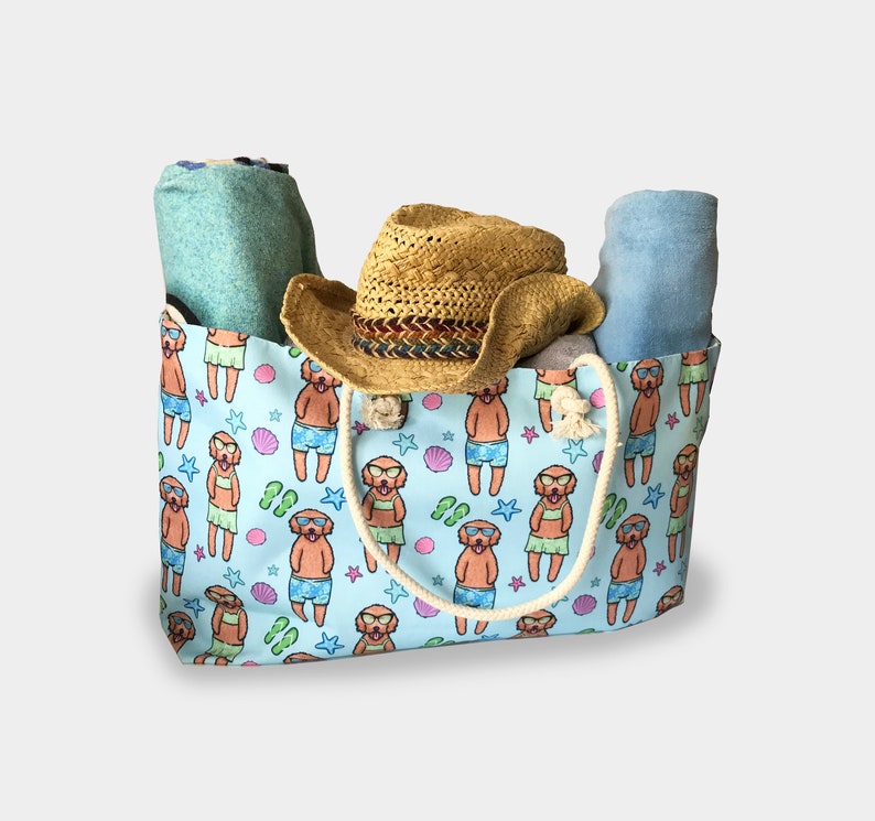May include: A blue and white tote bag with a pattern of dogs wearing sunglasses and swimsuits. The bag has a straw hat and two towels inside.