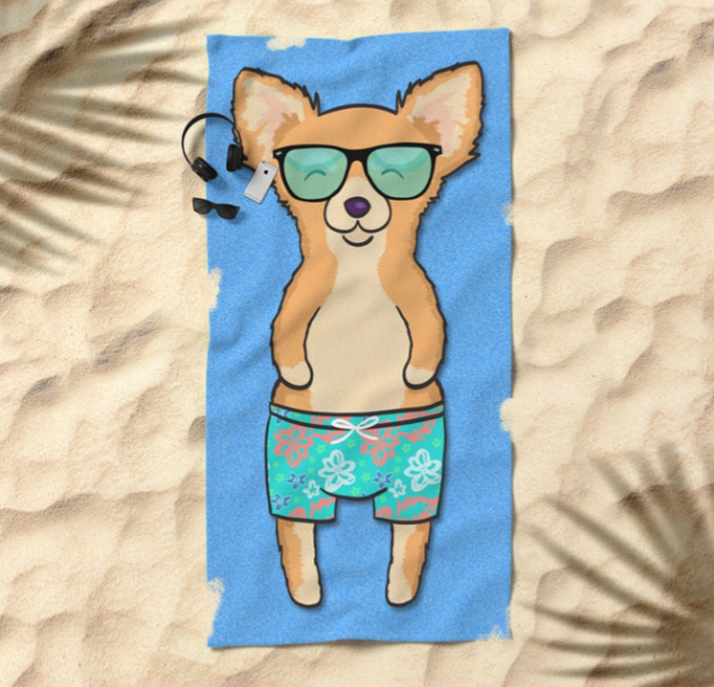 May include: A blue beach towel with a cartoon image of a chihuahua wearing sunglasses and floral swim trunks. The chihuahua is lying on its back with its paws in the air.