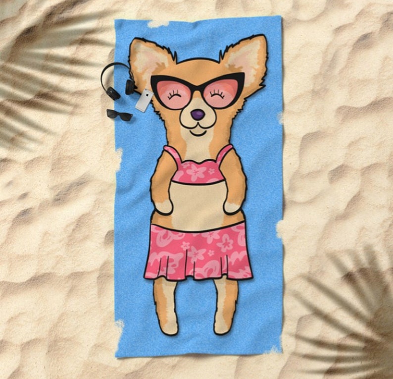 May include: A beach towel with a cartoon illustration of a chihuahua wearing sunglasses and a pink bikini. The chihuahua is lying on its back with its legs in the air. The towel is blue with a white border.