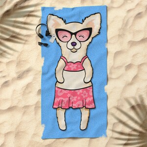 May include: A white chihuahua wearing pink sunglasses and a pink floral bikini is lying on a blue beach towel.