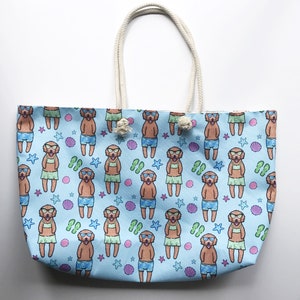 May include: A light blue tote bag featuring a pattern of dogs wearing sunglasses and leis. The dogs are brown and white and are surrounded by seashells, starfish, and flip-flops.