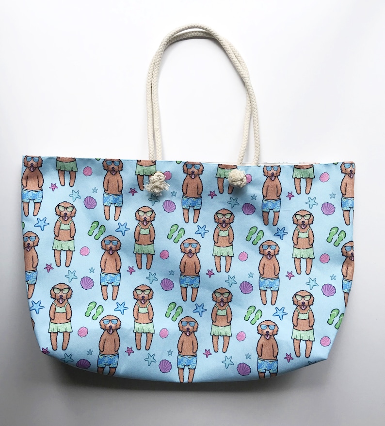 May include: A light blue tote bag featuring a pattern of dogs wearing sunglasses and leis. The dogs are brown and white and are surrounded by seashells, starfish, and flip-flops.