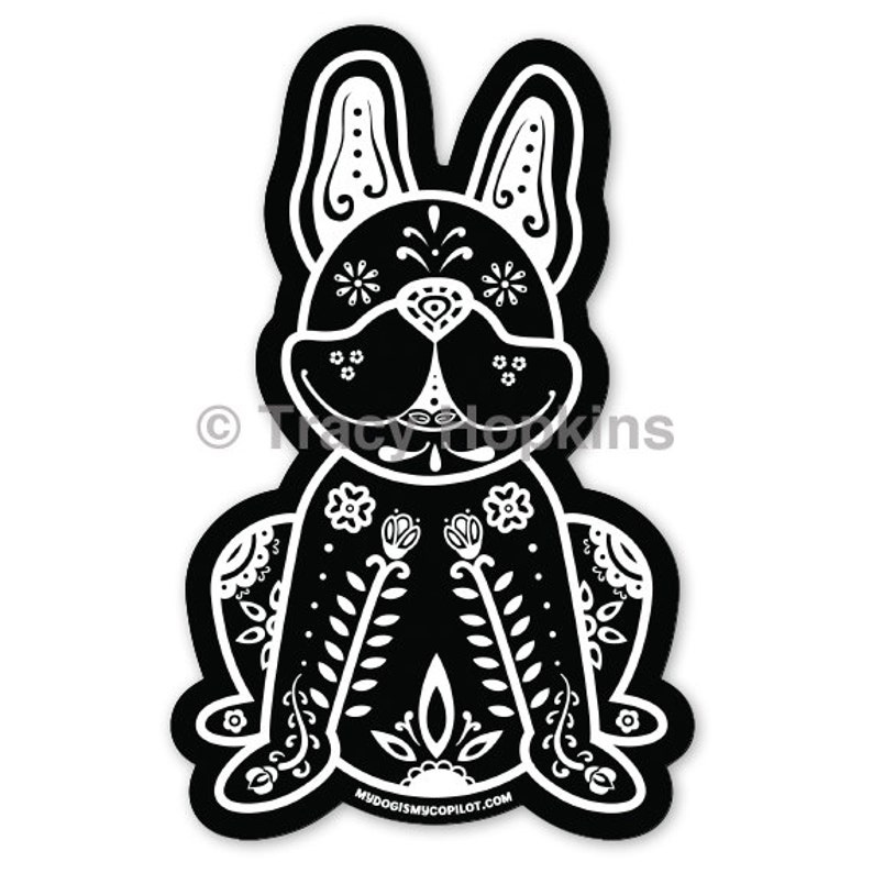 May include: Black and white illustration of a French bulldog with a Day of the Dead sugar skull design. The dog is sitting with its legs crossed and has a floral pattern on its body.