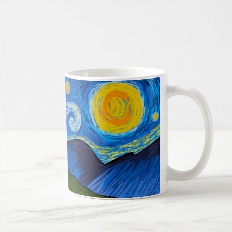 Op de afbeelding: Witte keramische mok met een blauw en geel sterrennachtontwerp. Het ontwerp bevat een grote gele zon en een donkerblauw berggebied.