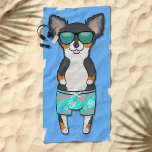 May include: A black and tan chihuahua wearing sunglasses and floral swim trunks is lying on a blue beach towel.