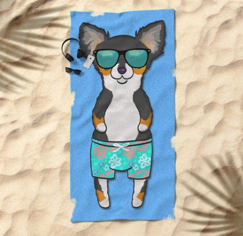 May include: A black and tan chihuahua wearing sunglasses and floral swim trunks is lying on a blue beach towel.