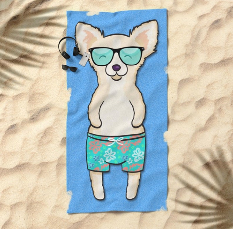 May include: A white chihuahua wearing sunglasses and blue and green floral swim trunks on a blue beach towel.
