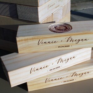 Puede incluir: Bloques de madera clara con la inscripci&oacute;n "Vinnie + Megan" y la fecha "05.24.2020". Un bloque tiene una hendidura circular. Los bloques parecen ser para un juego o decoraci&oacute;n.
