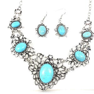 close-up shot of filigree turquoise necklace and earring set, antique silver color, for women.