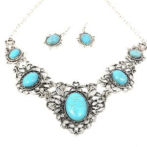 close-up shot of filigree turquoise necklace and earring set, antique silver color, for women.