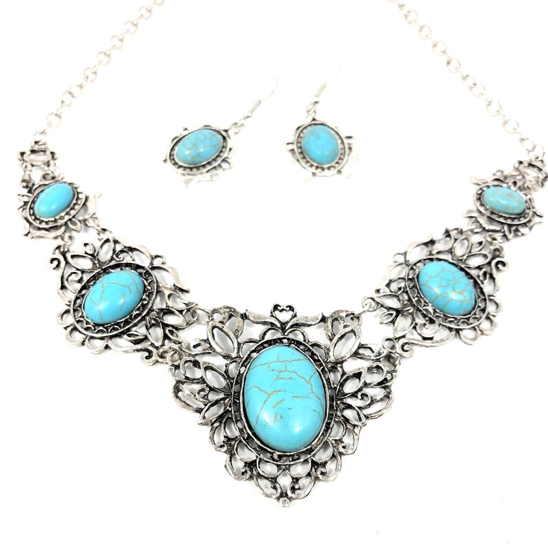 close-up shot of filigree turquoise necklace and earring set, antique silver color, for women.