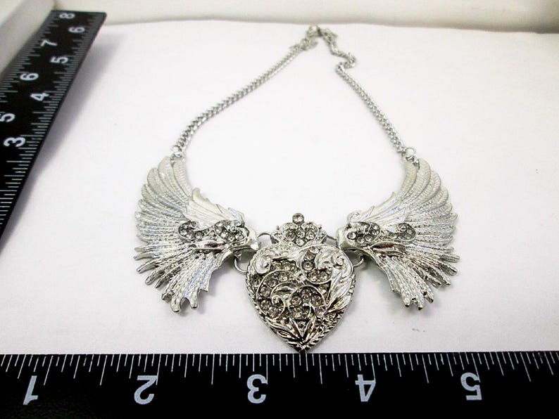 large angel wings with heart bib necklace with measurement indicator