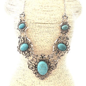 filigree turquoise necklace on mannequin, antique silver color, for women.