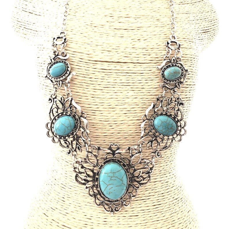 filigree turquoise necklace on mannequin, antique silver color, for women.