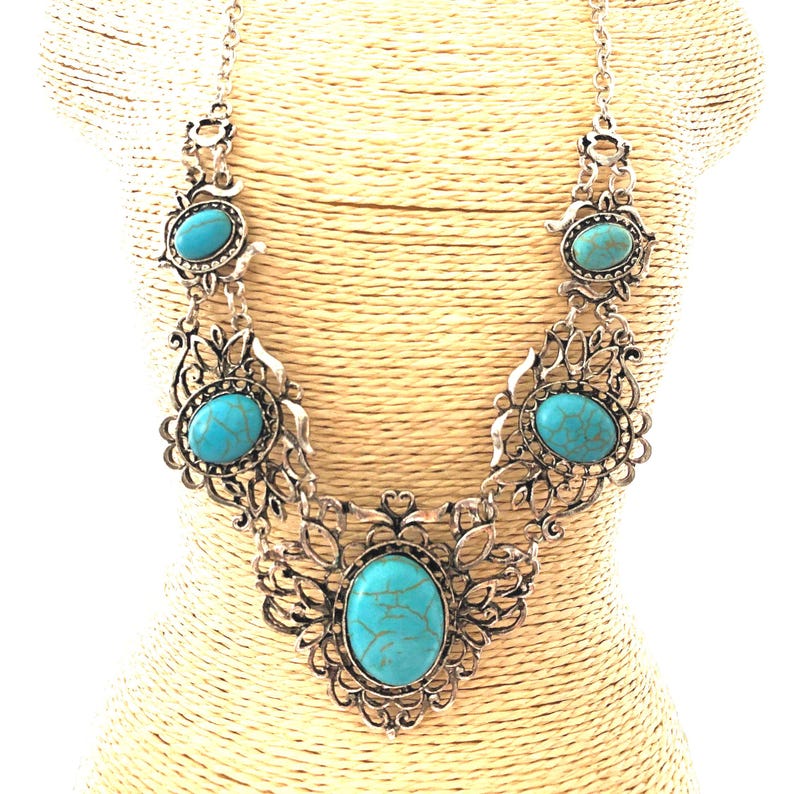 filigree turquoise necklace on mannequin, antique silver color, for women.