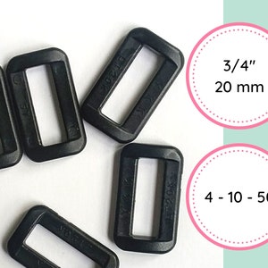 Op de afbeelding: Een close-up van zwarte plastic schuifgespen, met een maat van 3/4 inch of 20 mm. De tekst "4 - 10 - 50" is zichtbaar op een van de gespen.