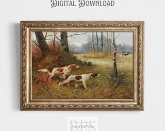 May include: A vintage painting of two hunting dogs in a forest setting. The dogs are brown and white with long ears and are standing in a field of tall grass. The background is a forest with trees and a cloudy sky. The painting is framed in a gold frame.