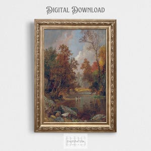 May include: A framed painting depicting a landscape scene with a river, trees, and a boat with people in it. The trees are in autumn colours of red, orange, and yellow. The river is calm and reflective. The painting is in a gold frame.